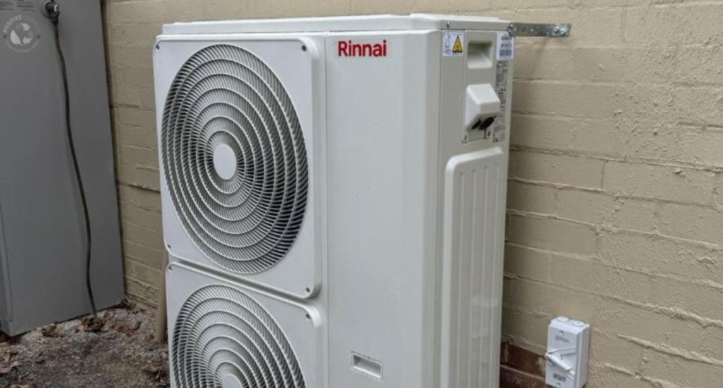  Rinnai outdoor split-system air conditioner installed against a brick wall, illustrating energy-efficient heating and cooling upgrades